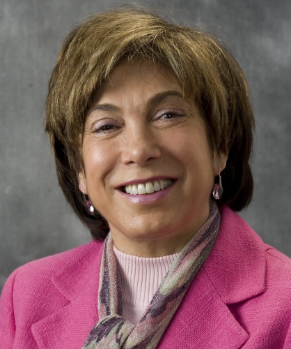 Headshot of Laura Tyson in pink suit jacket and colorful scarf.